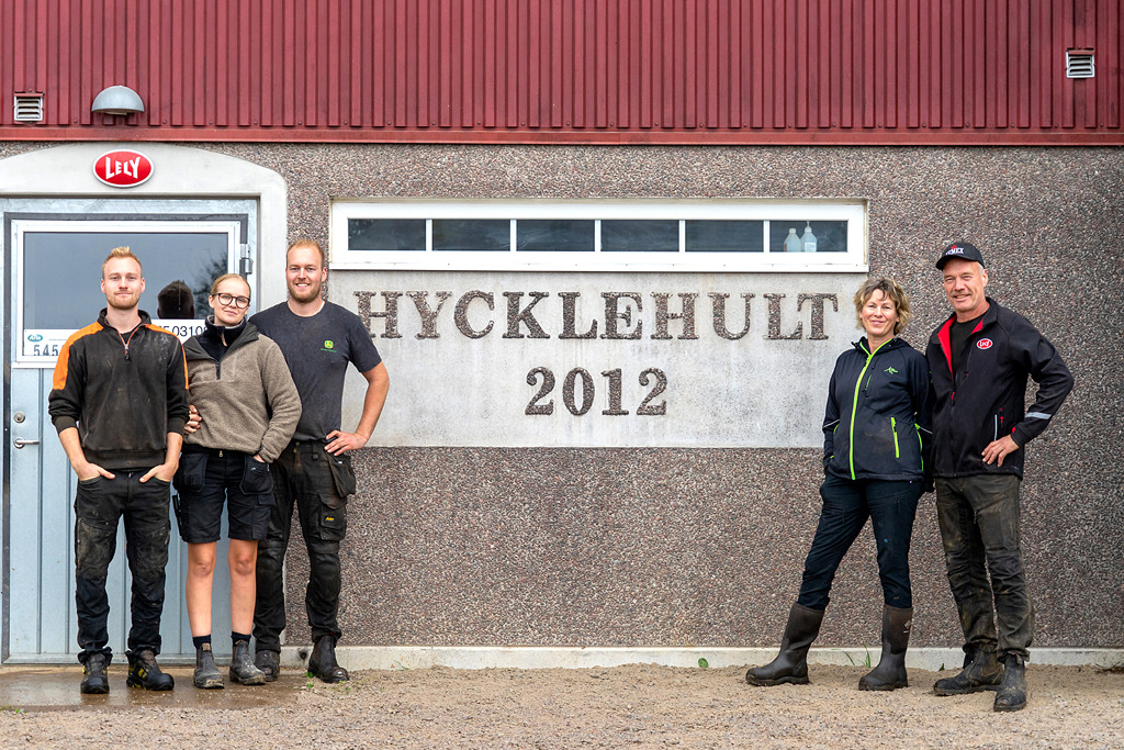 Fem personer framför betonggrunden till ett stall med texten Hycklehult 2012. 